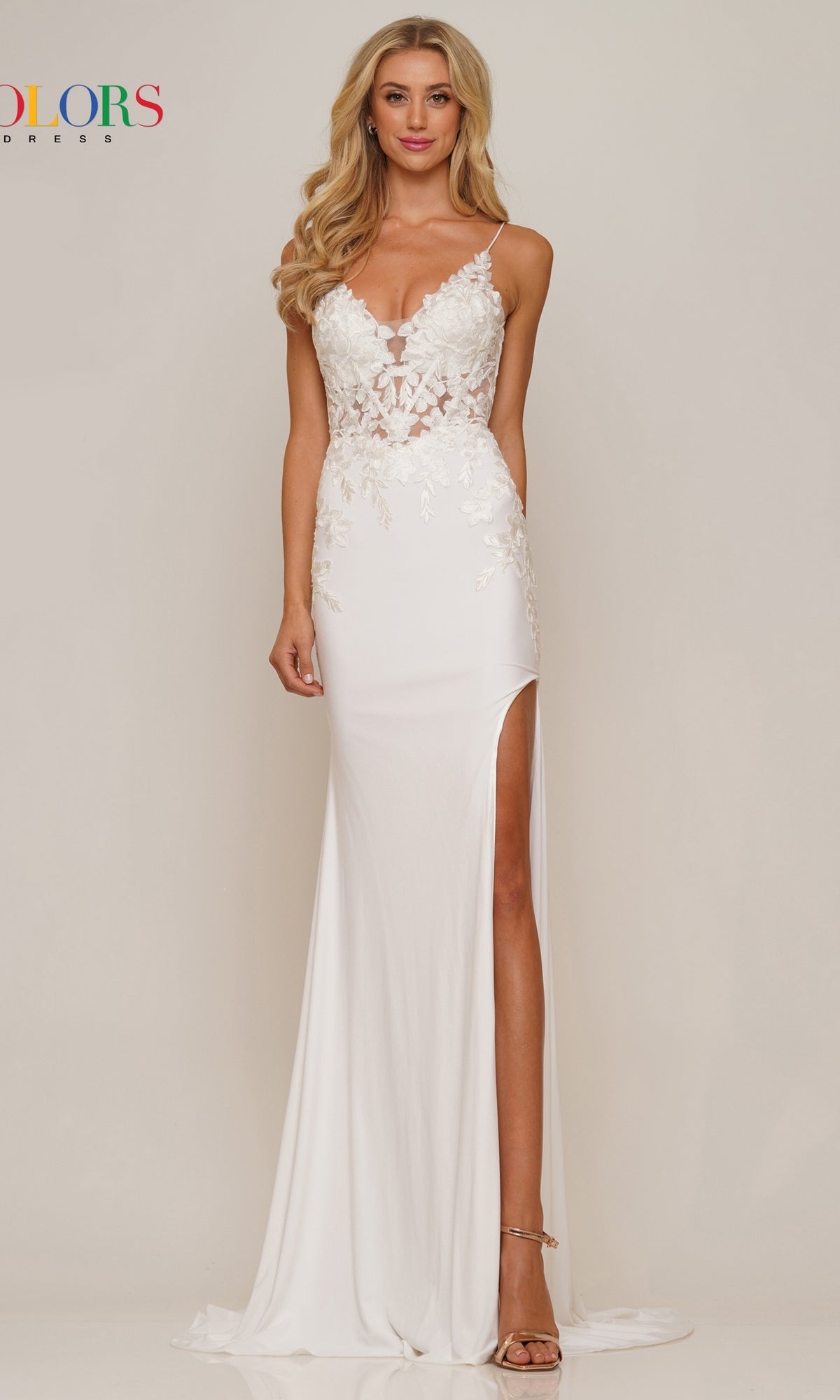 A woman stands against a plain light background wearing the Lace-Up Open-Back Slinky Long Prom Dress G1086, featuring a long white silhouette with lace details, deep neckline, high slit, and open back.